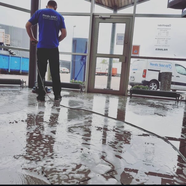 A person using a window squeegee to clean a glass surface.